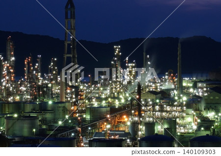 Night view of a factory shrouded in smoke 140109303