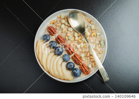 Oatmeal. Bowl of oatmeal porridge with blackberry, bananas and chia seeds on gray concrete old table background. Top view in flat lay style. Natural ingredients. Hot healthy breakfast and diet food 140109646