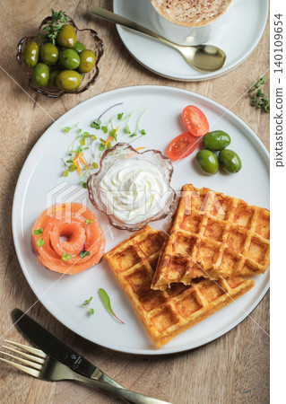 Crunchy waffle fries with sour cream dip served in a basket 140109654