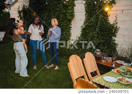 Multi ethnic women and child having backyard party fun Multi ethnic women and child having backyard party fun 140109701