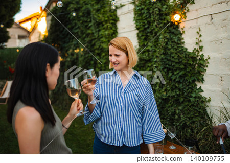 Diverse friends enjoying wine at outdoors backyard party Diverse friends enjoying wine at outdoors backyard party 140109755