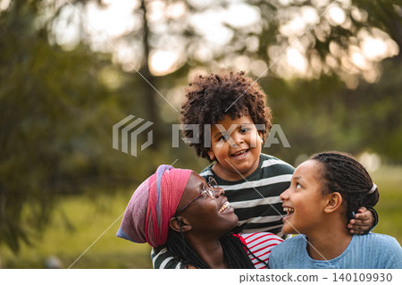 Mother and children laughing enjoying outdoor family time Mother and children laughing enjoying outdoor family time 140109930