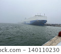 A large ferry docked in a harbor shrouded in thick fog. 140110230