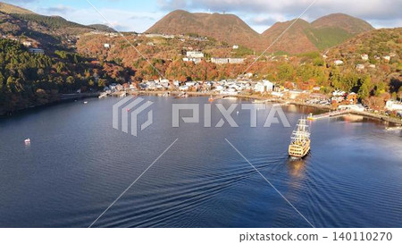 A pirate ship sailing on Lake Ashi in autumn, with an aerial view of the townscape of Moto-Hakone. A pirate ship sailing on Lake Ashi in autumn, with an aerial view of the townscape of Moto-Hakone. 140110270