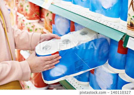 Toilet paper in hands of buyer at store Toilet paper in hands of buyer at store 140110327