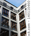 Modern apartment building facade with white walls, large windows and black balcony railings 140110460