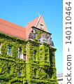 Ivy covered historic building with tiled roof. Concept of urban architecture 140110464