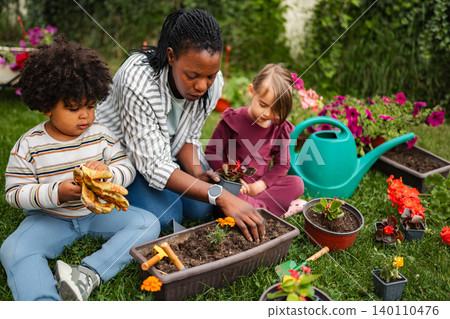 Family bonding planting flowers in backyard garden 140110476
