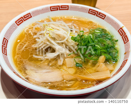 醬油拉麵。上面鋪著豆芽、蔥花、筍片和叉燒肉。美味滾燙的湯麵,表面漂浮著一層油。 醬油拉麵。上面鋪著豆芽、蔥花、筍片和叉燒肉。美味滾燙的湯麵,表面漂浮著一層油。 140110750