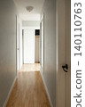 Wooden front door with doormat in home entrance hallway 140110763