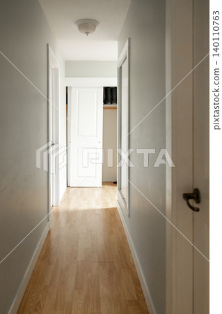 Wooden front door with doormat in home entrance hallway 140110763