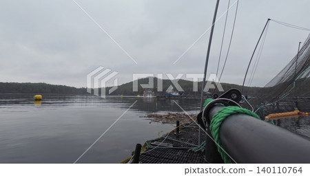 Large fish farm in the water with nets under cloudy sky as background 140110764