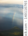 Rainbow arc bending over forest hill and lake 140110765