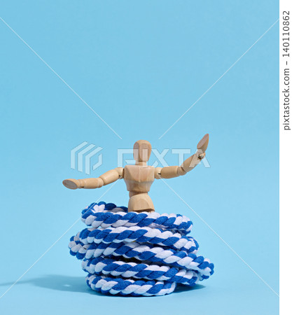 A wooden mannequin with raised arms is released from a trap shaped like a skein of blue and white rope a A wooden mannequin with raised arms is released from a trap shaped like a skein of blue and white rope a 140110862