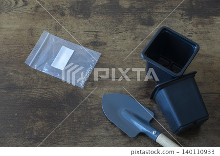 Gardening tools, seed packet and plastic pots on wooden table Gardening tools, seed packet and plastic pots on wooden table 140110933