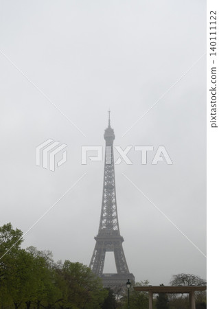 Low visibility view of Eiffel Tower in heavy fog, moody weather in Paris Low visibility view of Eiffel Tower in heavy fog, moody weather in Paris 140111122