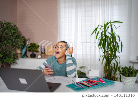 Young girl enjoying online content or communication at home 140111310