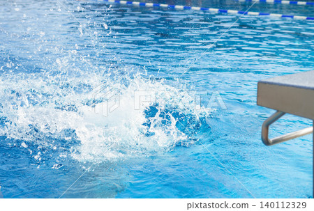 Refreshing splash in a clear blue swimming pool with diving board, capturing dynamic motion, summer leisure, water sport activity, vacation atmosphere Refreshing splash in a clear blue swimming pool with diving board, capturing dynamic motion, summer leisure, water sport activity, vacation atmosphere 140112329