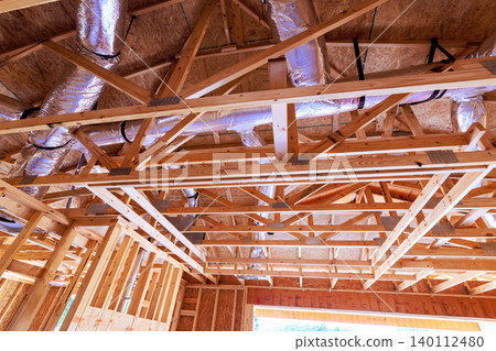Workers are building wooden frame with ductwork in new construction site tools materials are visible. Workers are building wooden frame with ductwork in new construction site tools materials are visible. 140112480
