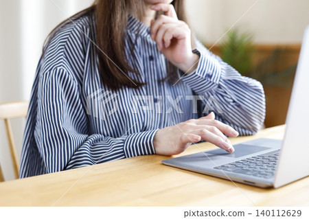 一位女士看著電腦螢幕,似乎在思考。 一位女士看著電腦螢幕,似乎在思考。 140112629
