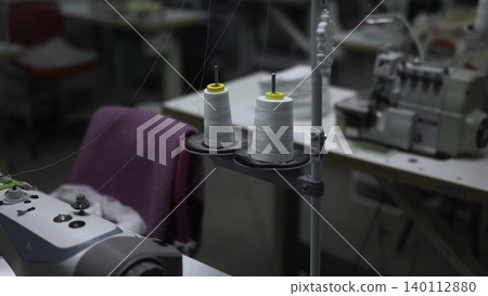 Concentrated Spools And Bobbins Foreground Contrasted By Busy Workshop With Machinery In Background. Media 140112880
