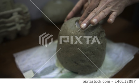 Smoothing Pottery With Gentle Motions. Artist Carefully Shapes Pottery On Clothcovered Surface. Media Smoothing Pottery With Gentle Motions. Artist Carefully Shapes Pottery On Clothcovered Surface. Media 140112897