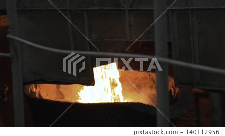 Molten Metal Pouring. Interior Of Glowing Furnace With Molten Metal Pouring Into Crucible From Ladle . Stock clip Molten Metal Pouring. Interior Of Glowing Furnace With Molten Metal Pouring Into Crucible From Ladle . Stock clip 140112956