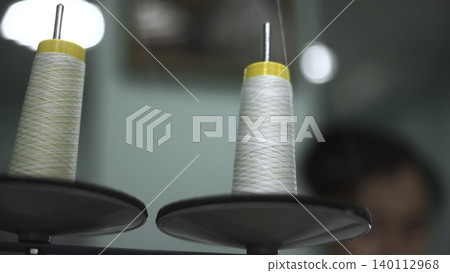 Thread Cones Focus. Detailed Image Showcasing Threads On Sewing Machine With Blurred Background. Media Thread Cones Focus. Detailed Image Showcasing Threads On Sewing Machine With Blurred Background. Media 140112968