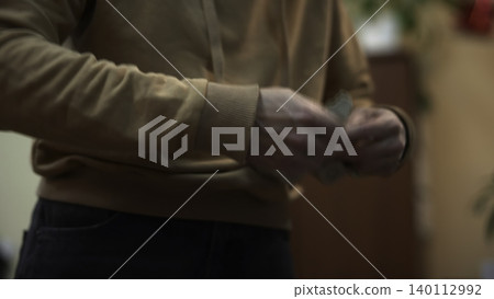 Close Examination Of Hands Carefully Adjusting Tiny Metal Pieces Indoors With Hoodie Visible. Media 140112992