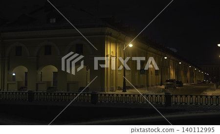 Snowy Street With Glowing Buildings. Quiet City Street Under Streetlights With Arched Architecture. Media Snowy Street With Glowing Buildings. Quiet City Street Under Streetlights With Arched Architecture. Media 140112995