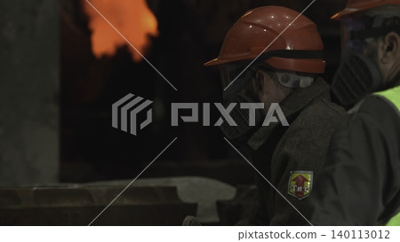 Metalworker Inspecting Surface. Focused Foundry Employee Examining Heated Metal Surface Carefully . Stock clip 140113012