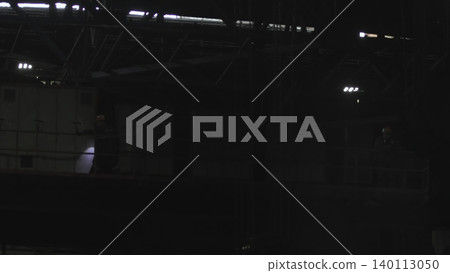 Cinematic Industrial Environment Featuring Technicians Under Lights Inspecting Schematics Amidst Shadows . Stock clip 140113050
