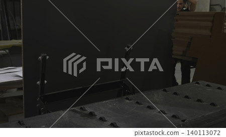 Workers Coordinate Effort To Place Heavy Black Panel Onto Loading Frame Near Conveyor System . Media Workers Coordinate Effort To Place Heavy Black Panel Onto Loading Frame Near Conveyor System . Media 140113072