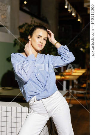 Woman posing in casual fashion outfit in restaurant Woman posing in casual fashion outfit in restaurant 140113300