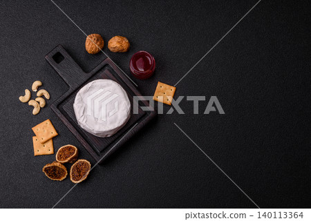Pink Brie or Camembert cheese with honey, jam, figs, and crackers. Brie cheese Pink Brie or Camembert cheese with honey, jam, figs, and crackers. Brie cheese 140113364
