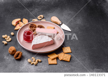 Pink Brie or Camembert cheese with honey, jam, figs, and crackers. Brie cheese Pink Brie or Camembert cheese with honey, jam, figs, and crackers. Brie cheese 140113371