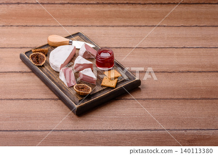 Pink Brie or Camembert cheese with honey, jam, figs, and crackers. Brie cheese Pink Brie or Camembert cheese with honey, jam, figs, and crackers. Brie cheese 140113380