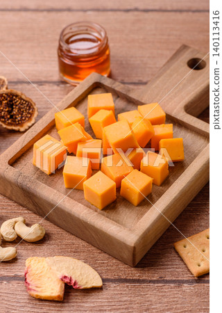Hard yellow cheddar cheese for sandwiches or pasta. Cheddar cheese 140113416