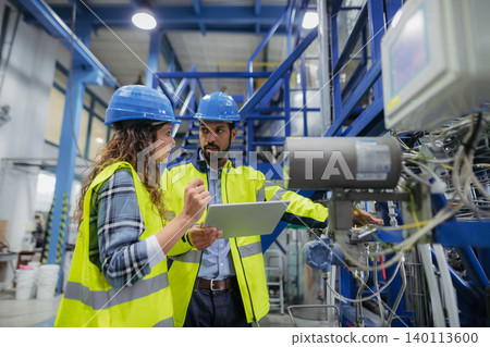 Industrial workers supervising automated manufacturing systems. Industrial workers supervising automated manufacturing systems. 140113600