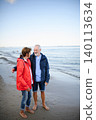 Romantic walk on beach for elderly couple in love. 140113634