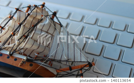 Toy Model Of Sailing Ship Lies On Blank Computer Keypad Toy Model Of Sailing Ship Lies On Blank Computer Keypad 140113654