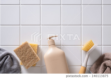 Beige cleaning bottle with brush and sponge on tile background Beige cleaning bottle with brush and sponge on tile background 140113875