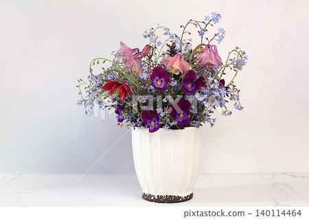 Still life with beautiful spring flowers blooming forget-me-nots,columbine, viola in vase on elegant background. Abstract floral arrangement and banner for screen, floral holiday card Still life with beautiful spring flowers blooming forget-me-nots,columbine, viola in vase on elegant background. Abstract floral arrangement and banner for screen, floral holiday card 140114464