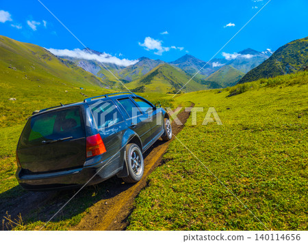 Black Station Wagon Driving on Mountain Dirt Road in Kyrgyzstan Black Station Wagon Driving on Mountain Dirt Road in Kyrgyzstan 140114656