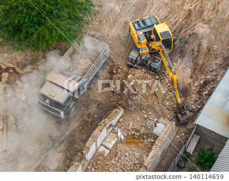 Aerial view of excavator and dump truck at construction site Aerial view of excavator and dump truck at construction site 140114659