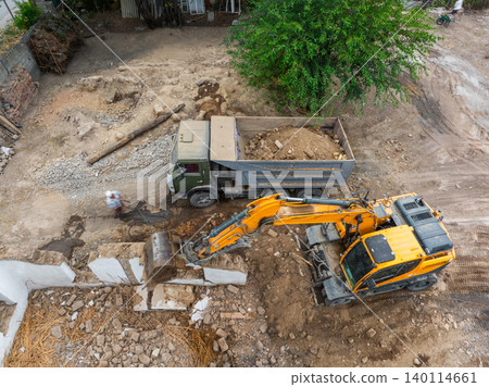 Aerial view of construction site with excavator and dump truck 140114661