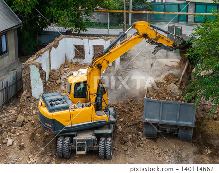 Excavator Clearing Debris at Demolition Site 140114662