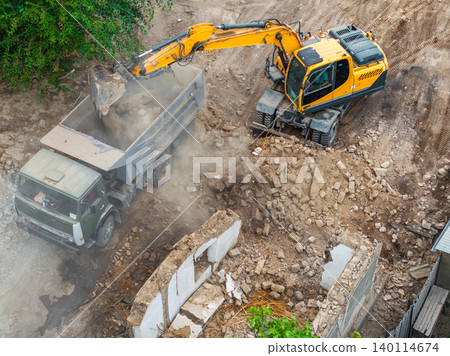 Excavator Loading Debris into Dump Truck at Construction Site Excavator Loading Debris into Dump Truck at Construction Site 140114674
