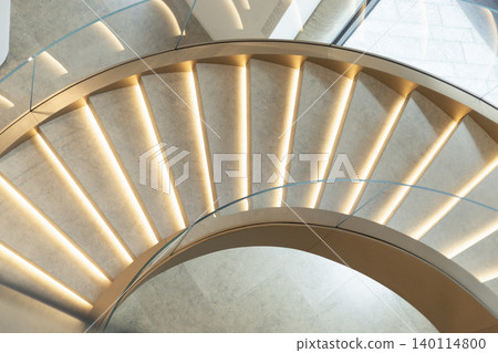 Curved staircase with illuminated steps and glass railing top down view Curved staircase with illuminated steps and glass railing top down view 140114800