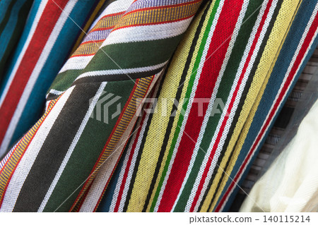 Close-up of colorful striped woven fabrics displaying vibrant traditional textile patterns 140115214